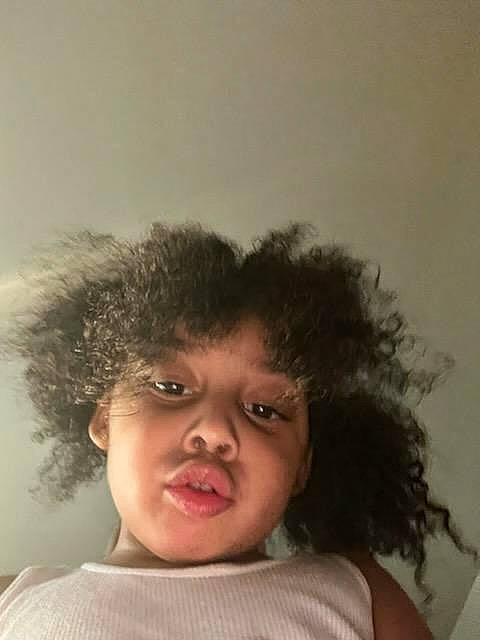 Kalani is registered to the contest to win money with this photo: afro, child, clothing, ear, eyelash, face, fashion_accessory, flash_photography, fun, hair, happy, headgear, headpiece, jheri_curl, lip, nose, person, ringlet, skin, t_shirt