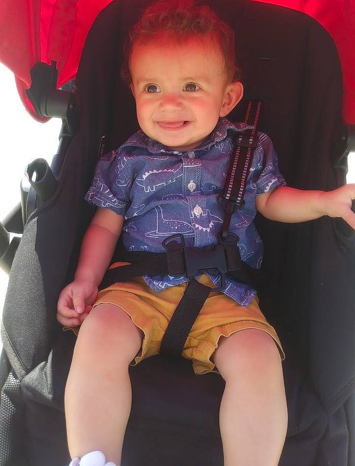 Jeffrey is registered to the contest to win money with this photo: baby_toddler_clothing, cheek, facial_expression, finger, hairstyle, hand, happy, human_body, joy, knee, lap, leg, mouth, person, pink, shorts, skin, smile, sneakers, textile