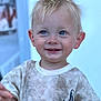 child, toddler, boy, blond_hair, blue_eyes, smile, shirt, cactus_print, dirty_clothes, portrait, face, happy, cute, young_child, casual_clothing, indoor, person, expression, light_background, small_child