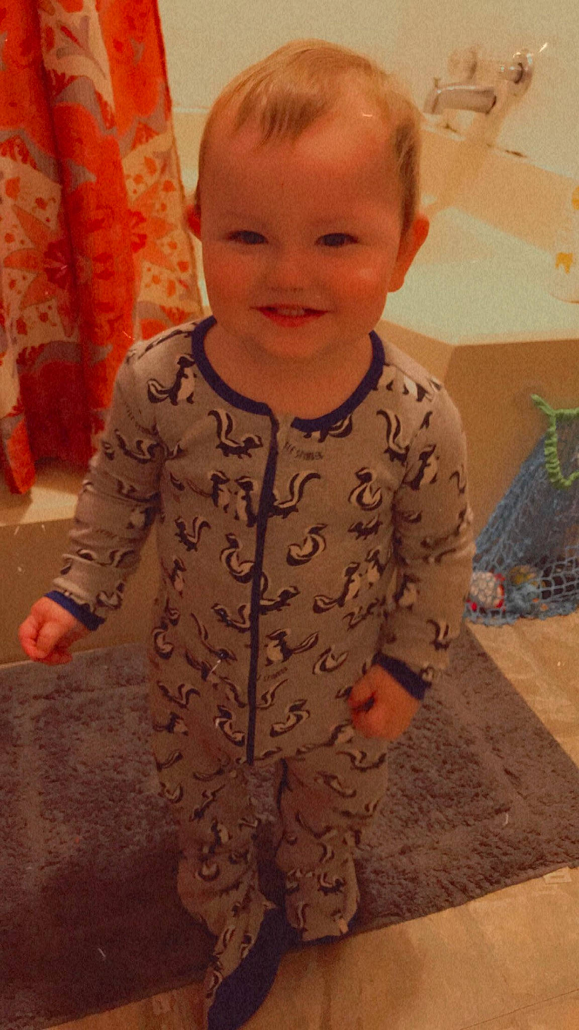 Greyson is registered to the contest to win money with this photo: baby, baby_toddler_clothing, cheek, child, eye, face, facial_expression, floor, flooring, hair, hairstyle, head, human_body, joy, nose, person, skin, sleeve, smile, standing