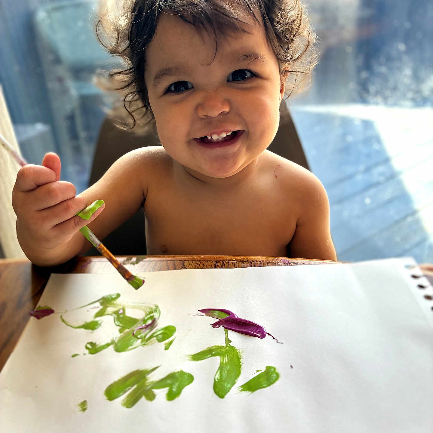 Aeradessa is registered to the contest to win money with this photo: art, brush, child, colorful, creative, curly_hair, expression, finger_paint, happy, indoor, messy, painting, paper, person, playful, portrait, smiling, table, toddler, young_child