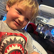 Grayson is registered to the contest to win money with this photo: blonde_hair, casual_clothing, child, cozy, cute, expression, face, hair, happy, home, indoor, person, portrait, shirt_graphic, short_sleeves, smiling, soft_lighting, toddler, tshirt, young_child