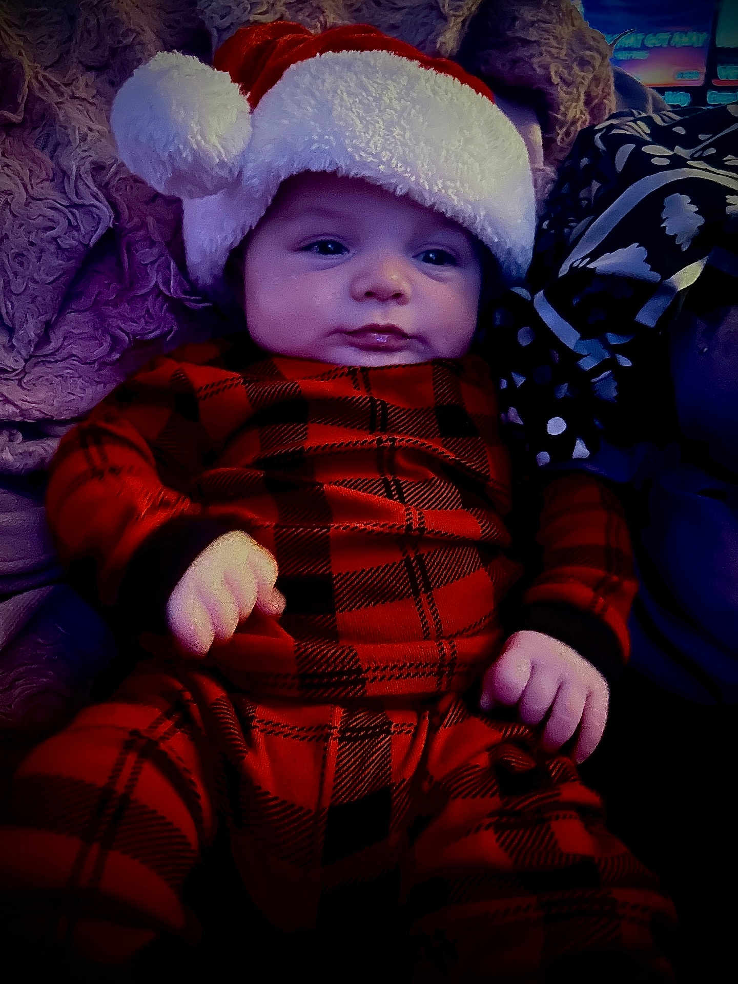 Ashtyn is registered to the contest to win money with this photo: baby, infant, santa_hat, plaid_clothing, red_pajamas, hands, face, cozy, blanket, soft_texture, indoor, portrait, child, cute, holiday, christmas, warm, sleepwear, resting, young