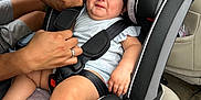 Jhaylani joined the competition — help win amazing prizes! baby, child, car_seat, car_interior, harness, straps, person, hands, seat_belt, grumpy_face, infant, clothing, car, safety, seat, transportation, adjusting, expression, cute, indoors