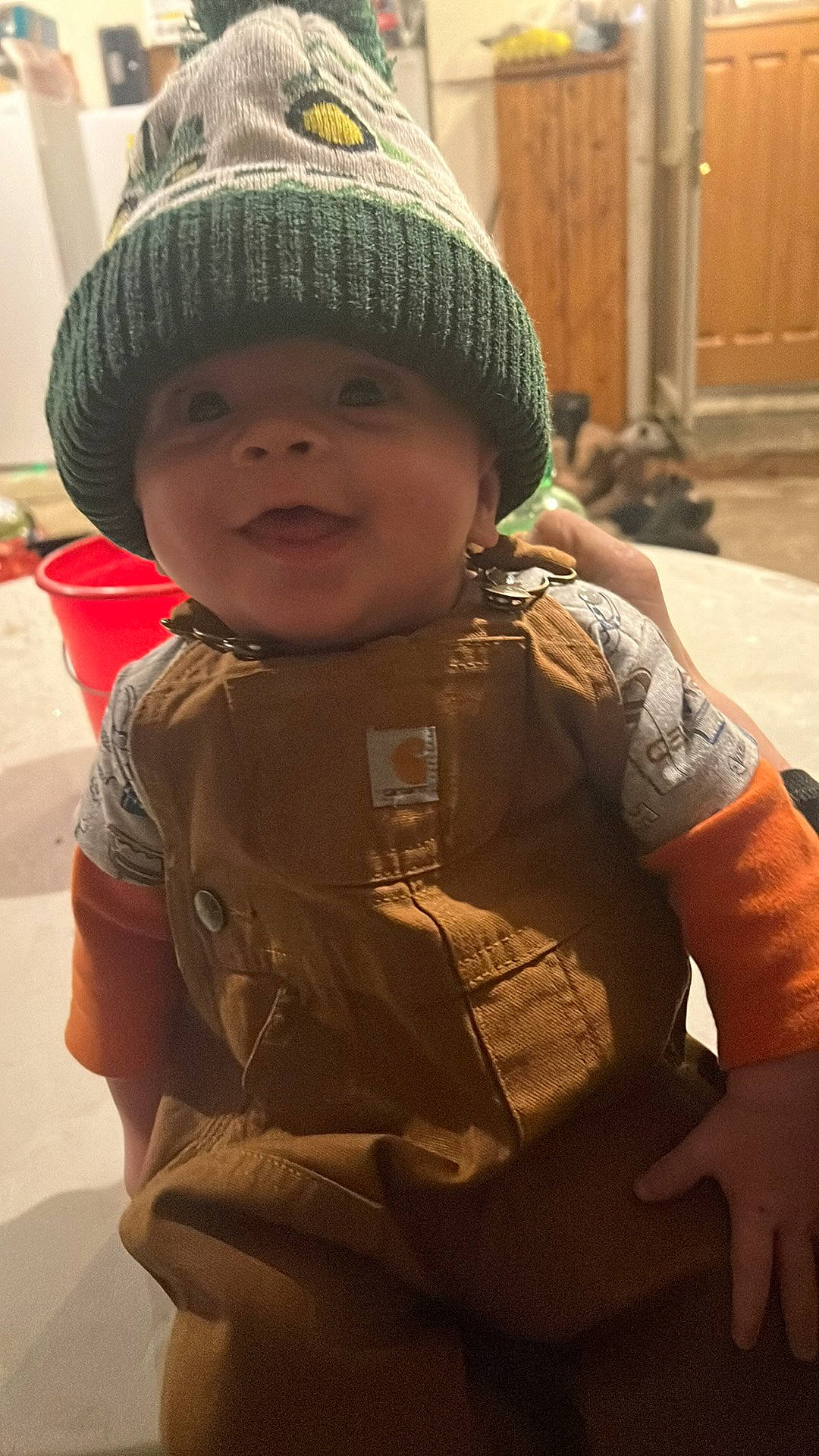 Cole is registered to the contest to win money with this photo: baby, beanie, cap, cheek, child, cool, fashion_accessory, fun, happy, headgear, helmet, knit_cap, military_camouflage, person, personal_protective_equipment, sitting, skin, smile, toddler, wool