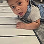 baby, carpet, child, clothing, curly_hair, cute, denim, drool, expression, eyes, face, floor, hand, head, indoor, mouth, person, striped_mat, surprised, toddler