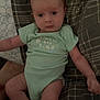 Oaklee joined the competition — help win amazing prizes! baby, infant, onesie, plaid_blanket, lying_down, curious_expression, indoor, child, young, cute, face, skin, head, arms, legs, soft_lighting, cozy, text_on_clothing, person, newborn