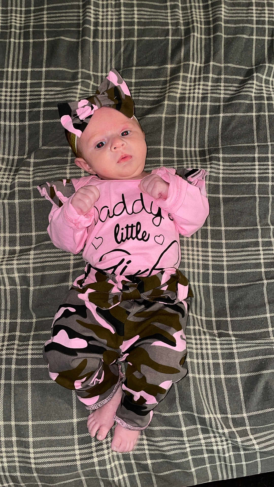 Oaklee joined the competition — help win amazing prizes! baby, infant, clothing, pink, camouflage, bow, blanket, plaid, feet, hands, face, portrait, lying_down, indoors, cute, newborn, child, person, apparel, fabric