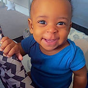 Carl joined the competition — help win amazing prizes! baby, child, smiling, blue_onesie, indoor, playpen, hand, face, cute, happy, infant, person, skin, young_child, eyes, mouth, fingertips, pattern, fabric, seated