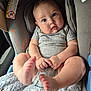 Austhin is registered to the contest to win money with this photo: baby, infant, car_seat, blanket, onesie, foot, toe, hand, cute, child, indoors, soft_texture, comfort, seat, car, expression, skin, portrait, looking_at_camera, young