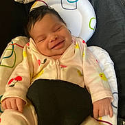 Kalani joined the competition — help win amazing prizes! baby, smiling, onesie, infant, cushion, baby_seat, patterned, cherry_pattern, flower_pattern, happy, closeup, face, hand, sleepy, cute, child, indoor, comfort, soft, resting
