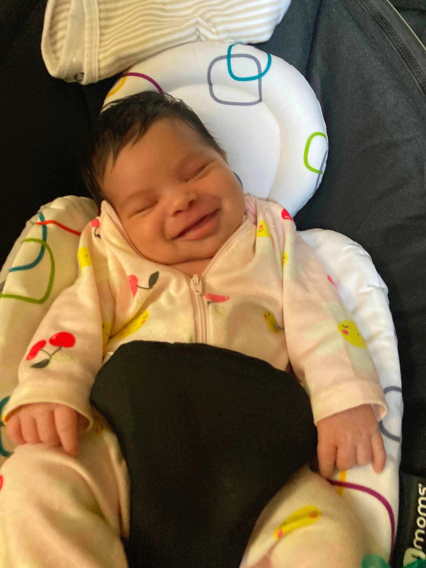 Kalani joined the competition — help win amazing prizes! baby, smiling, onesie, infant, cushion, baby_seat, patterned, cherry_pattern, flower_pattern, happy, closeup, face, hand, sleepy, cute, child, indoor, comfort, soft, resting