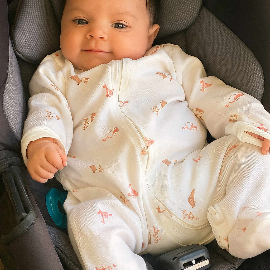 Kalani is registered to the contest to win money with this photo: baby, baby_clothes, car_seat, child, clothing, comfort, cute, face, happy, indoor, infant, infant_toddler, newborn, onesie, portrait, relaxed, seatbelt, smile, soft_lighting, young_child