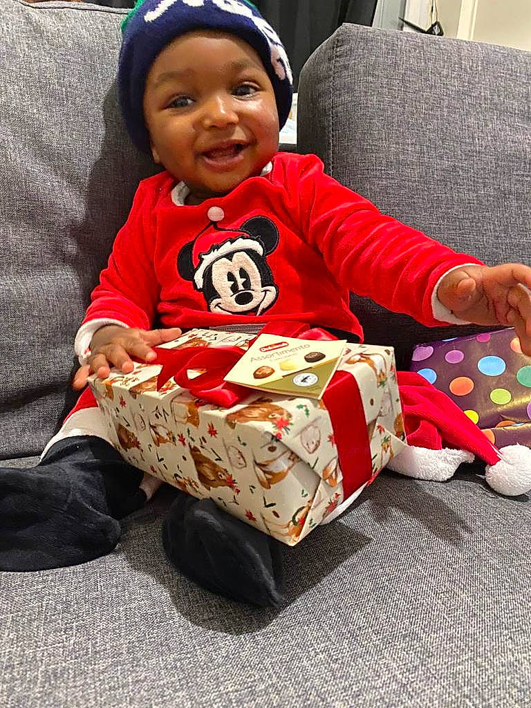 Dylan Maël a rejoint le concours — aidez-le/la à gagner de superbes lots ! baby, baby_toddler_clothing, beanie, cap, carmine, child, christmas, christmas_eve, comfort, facial_expression, fun, happy, headwear, holiday, person, play, room, sitting, sleeve, smile
