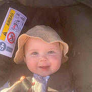 Lucas joined the competition — help win amazing prizes! baby, child, smiling, hat, bucket_hat, car_seat, seatbelt, straps, warning_label, airbag, infant, cute, happy, portrait, face, person, clothing, indoors, closeup, seat