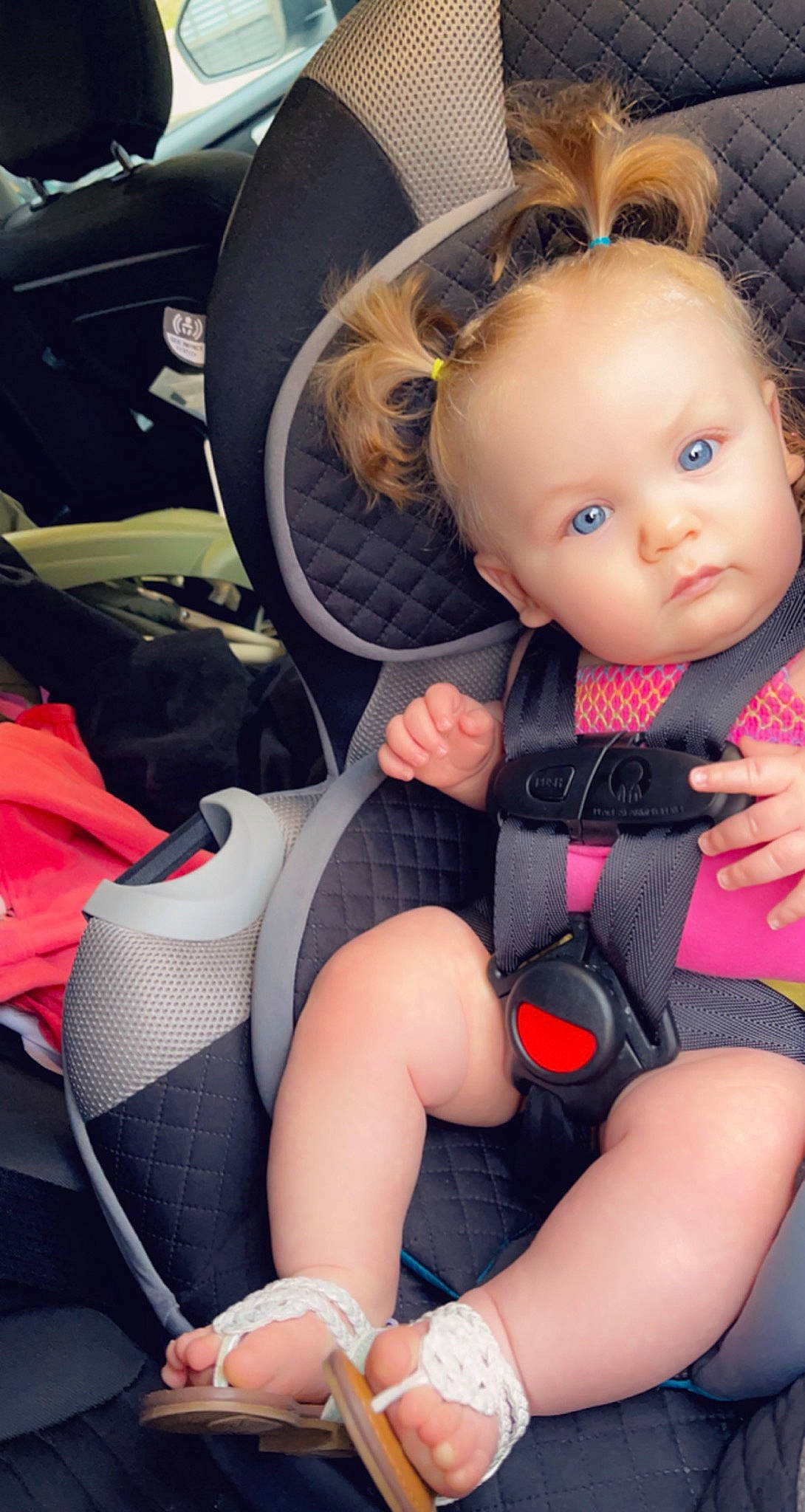 Kennedy is registered to the contest to win money with this photo: auto_part, automotive_design, baby_carriage, baby_products, baby_toddler_clothing, car_seat, comfort, doll, eyelash, head_restraint, human_leg, knee, lap, leg, person, sitting, steering_wheel, thigh, toddler, toy