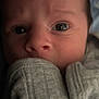 Hayden is registered to the contest to win money with this photo: baby, infant, close_up, face, eyes, clothing, grey, soft_light, cute, portrait, newborn, skin, expression, hands, cozy, young_child, indoors, person, sleeve, curious