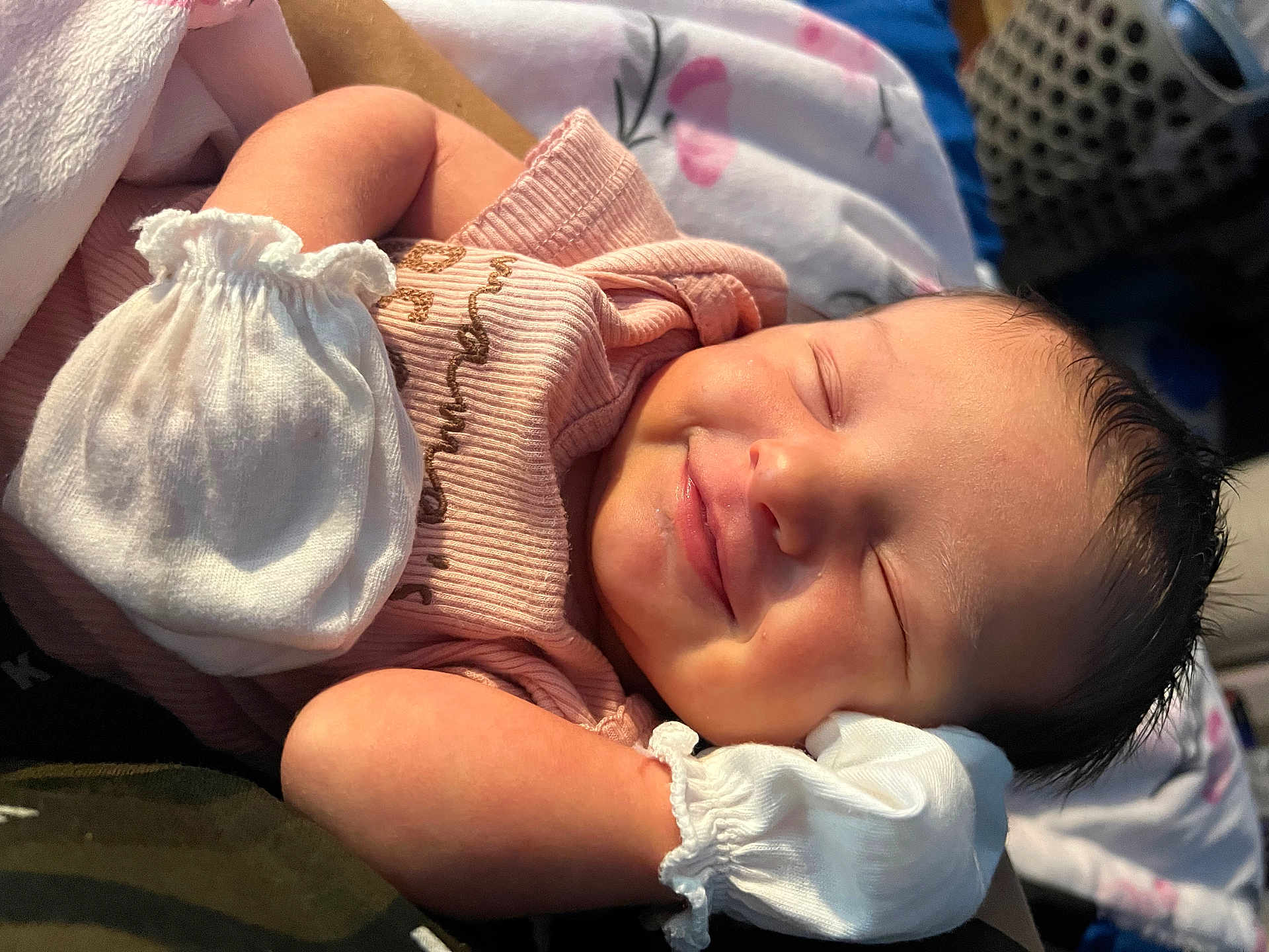 Miyah is registered to the contest to win money with this photo: baby, newborn, infant, sleeping, smile, mittens, pink_clothing, face, skin, hair, closeup, peaceful, soft_light, cute, portrait, child, resting, indoors, blanket, sleep