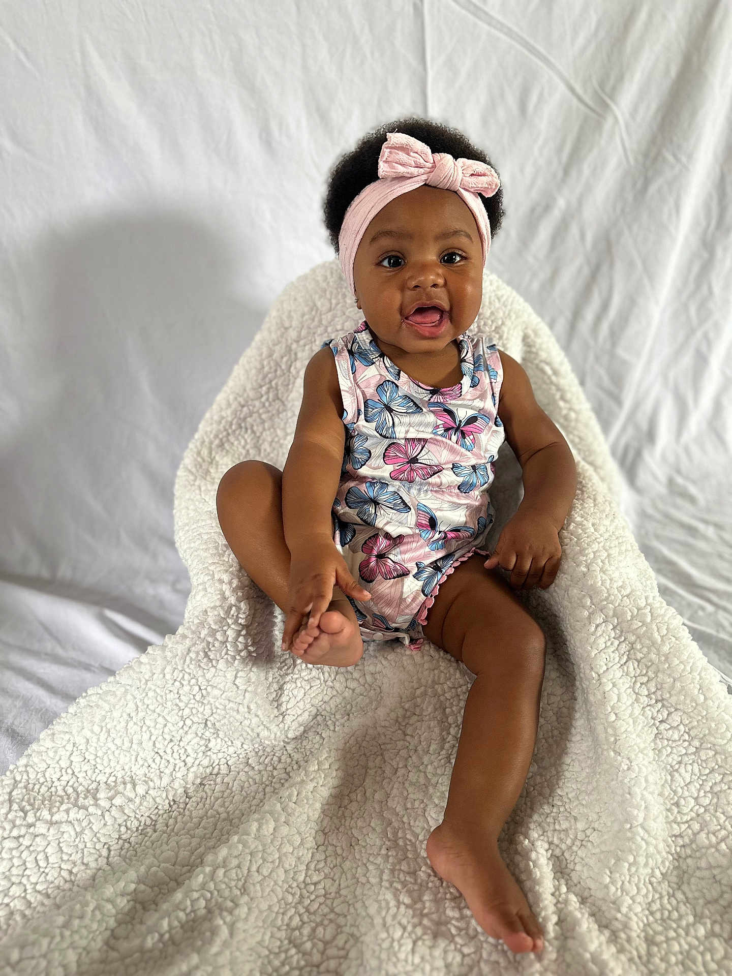 Cassidy is registered to the contest to win money with this photo: baby, blanket, clothing, couch, cushion, dress, face, furniture, happy, hat, head, homedecor, newborn, person, photography, portrait, quilt, sitting, smile, towel