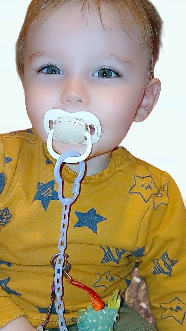 Ezyo participe au concours pour gagner de l'argent avec cette photo : accessories, baby, clothing, coat, couch, electronics, face, furniture, grass, head, jacket, jewelry, necklace, person, photography, plant, portrait, sitting, t_shirt, toy