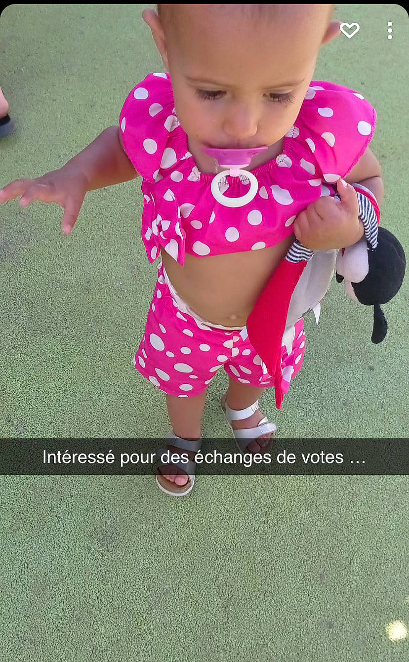 Liyah a rejoint le concours — aidez-le/la à gagner de superbes lots ! baby, baby_products, baby_toddler_clothing, cheek, child, finger, font, fun, grass, happy, head, headwear, human_body, magenta, pattern, person, pink, play, product, skin