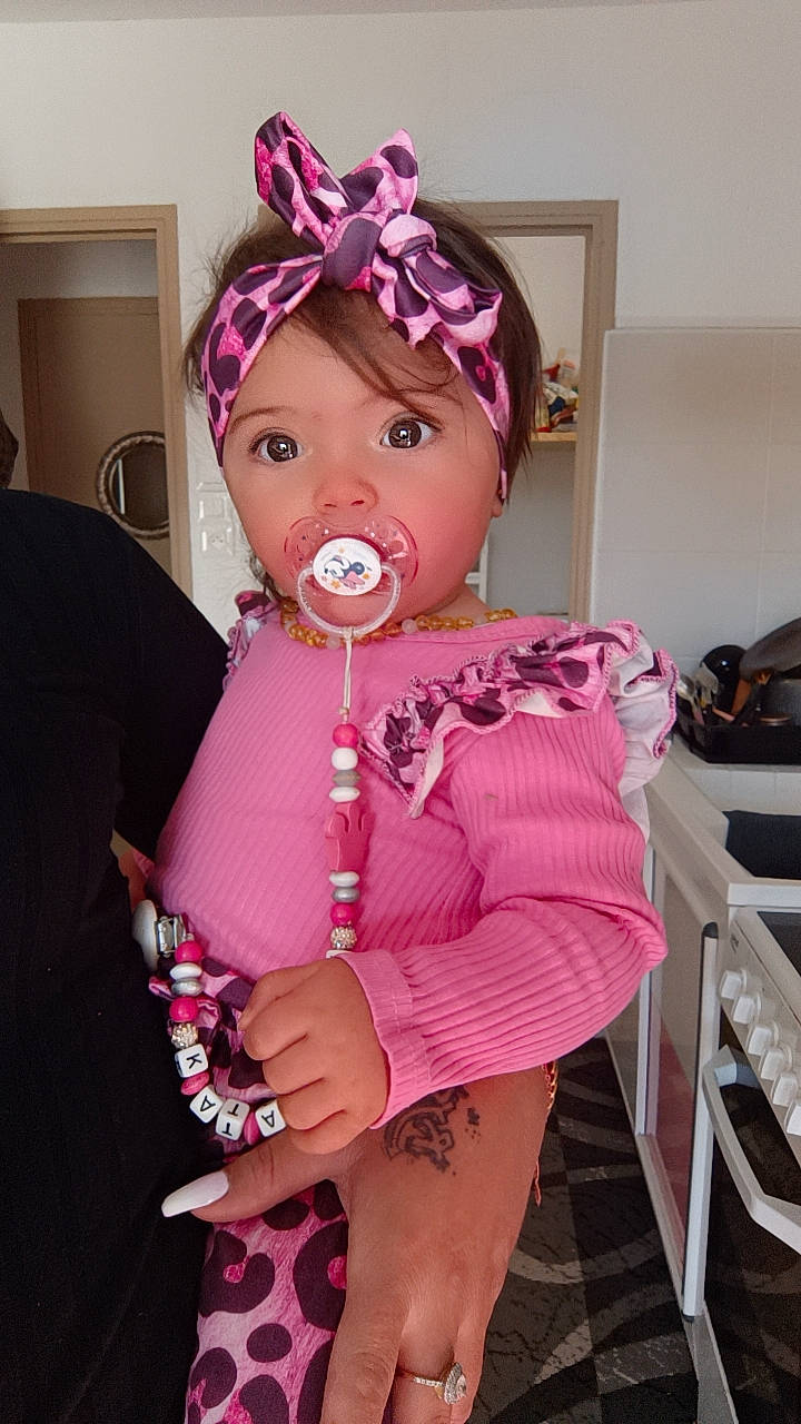 Katalëya a rejoint le concours — aidez-le/la à gagner de superbes lots ! baby, baby_products, baby_toddler_clothing, blond, chair, child, costume, costume_hat, event, eyelash, fashion_accessory, headband, headpiece, headwear, jewellery, lip, magenta, necklace, person, personal_protective_equipment