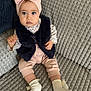baby, child, infant, pink_bow, headband, blue_eyes, couch, gray_couch, socks, pink_pants, floral_shirt, fur_vest, indoor, portrait, seated, cute, looking_at_camera, young_child, soft_lighting, cozy
