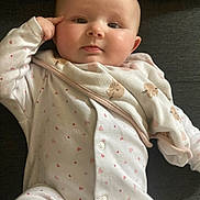 Daisy-Mae is registered to the contest to win money with this photo: baby, infant, face, onesie, blanket, heart_pattern, cozy, cute, child, portrait, couch, indoor, soft_lighting, skin, head, hand, expression, clothing, relaxing, person