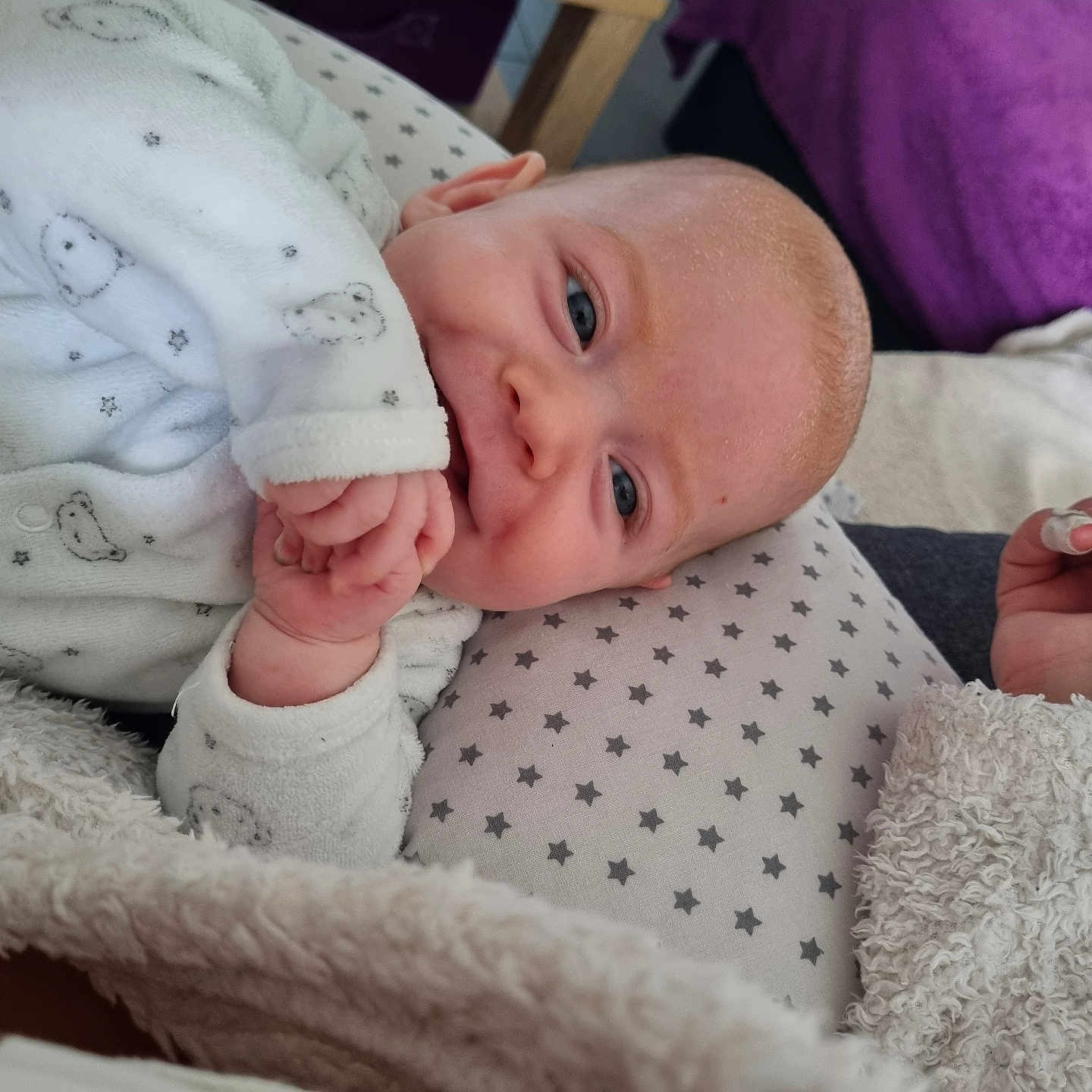 Wayan a rejoint le concours — aidez-le/la à gagner de superbes lots ! baby, blanket, blue_eyes, child, cozy, cute, face, fingers, hand, indoor, infant, lying_down, nails, onesie, person, pillow, sleepwear, smiling, soft_texture, stars