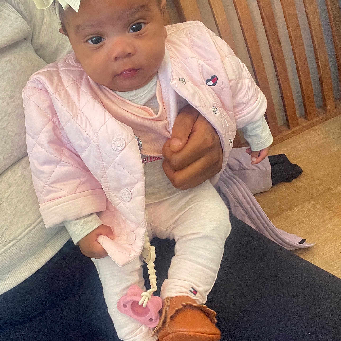 Sage Smith joined the competition — help win amazing prizes! baby, bow, casual, child, clothing, cozy, cute, hand, headband, holding, indoor, infant, looking_at_camera, moccasins, pacifier, person, pink_jacket, portrait, sitting, wooden_bench