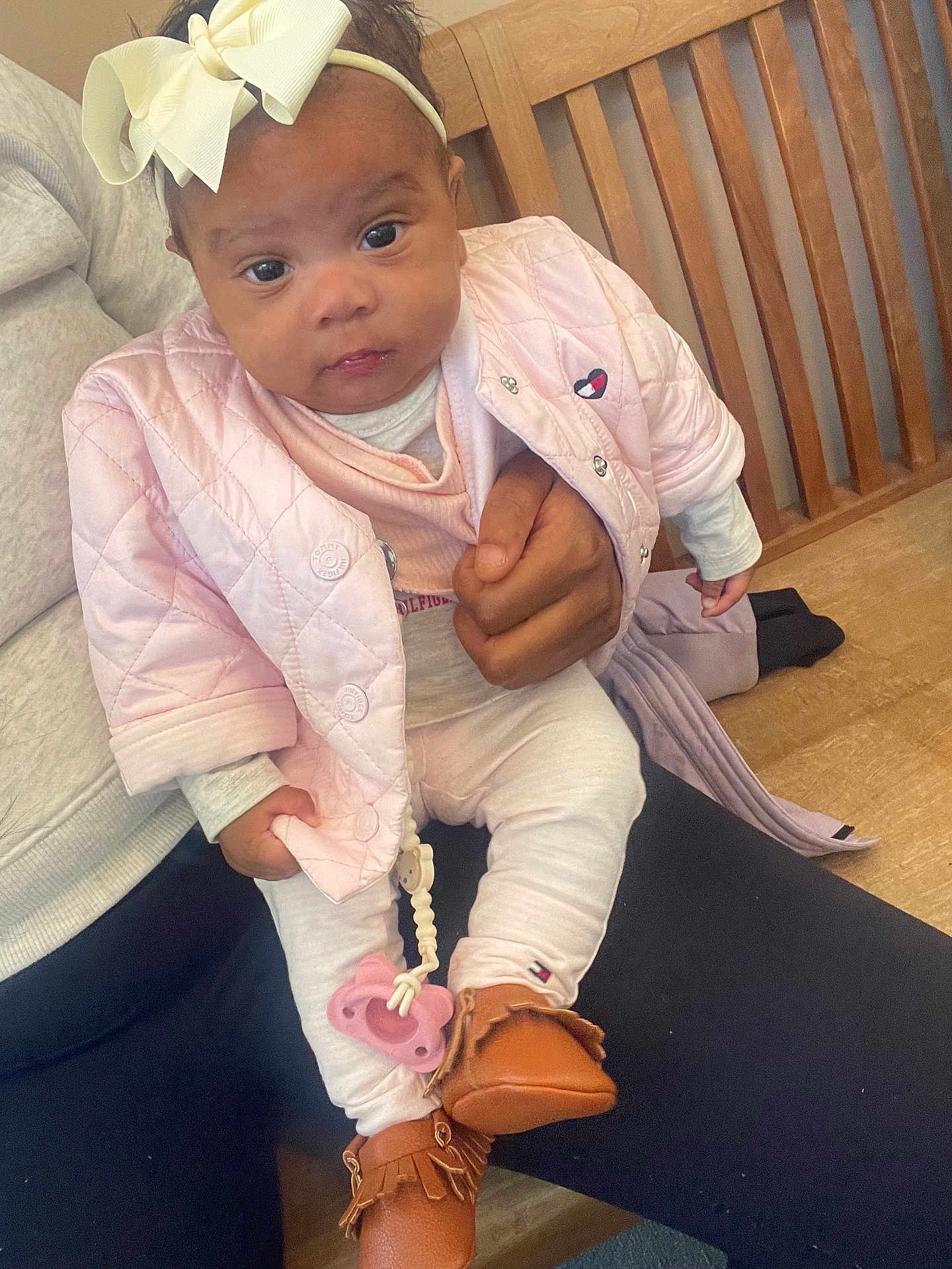 Sage Smith joined the competition — help win amazing prizes! baby, child, infant, pink_jacket, headband, bow, pacifier, moccasins, clothing, cute, person, indoor, wooden_bench, hand, sitting, portrait, looking_at_camera, cozy, casual, holding