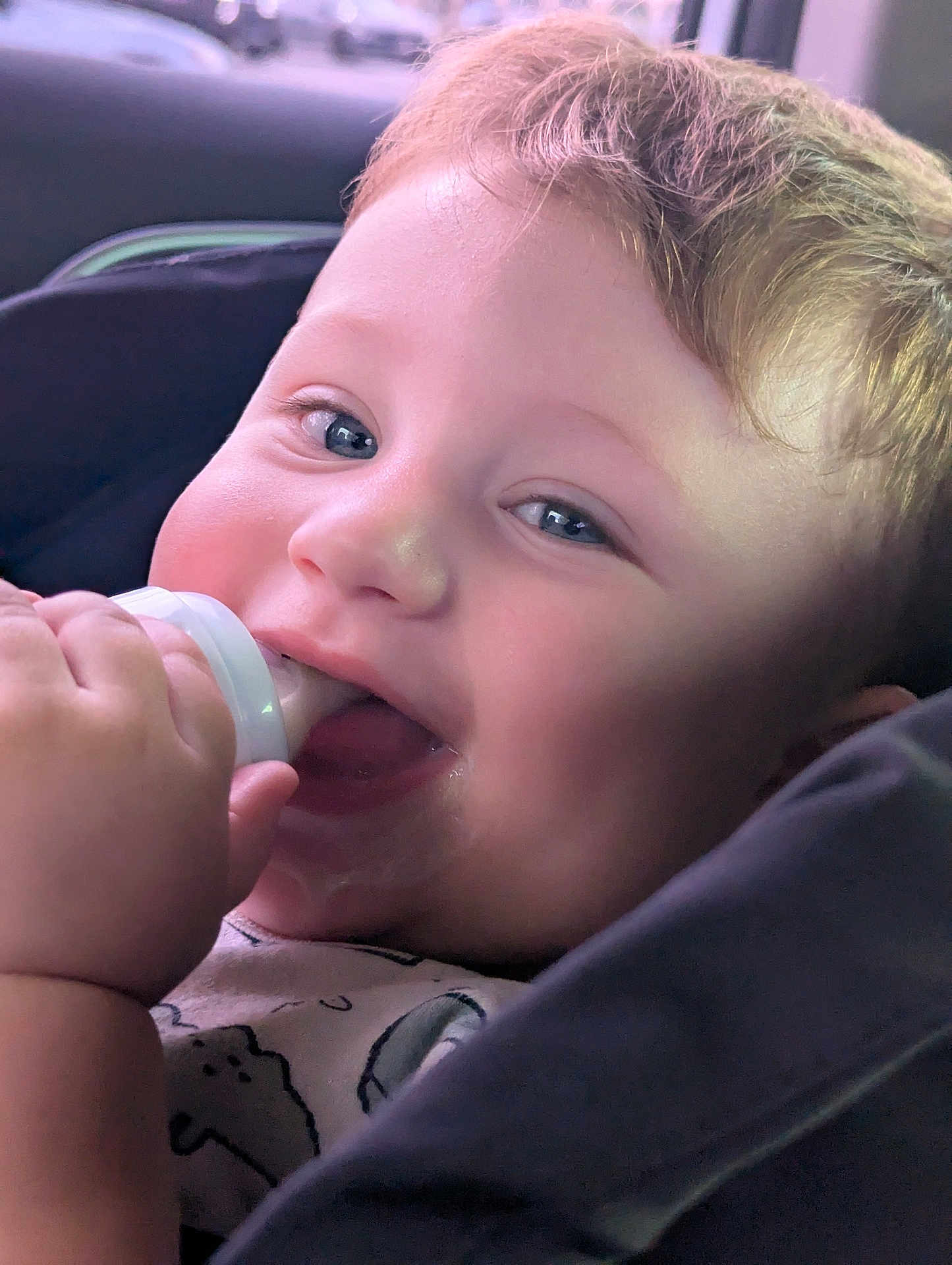 Isaac is registered to the contest to win money with this photo: baby, child, bottle, chewing, close_up, cute, face, hand, infant, joy, light, mouth, person, portrait, skin, smile, soft, toddler, young, young_child