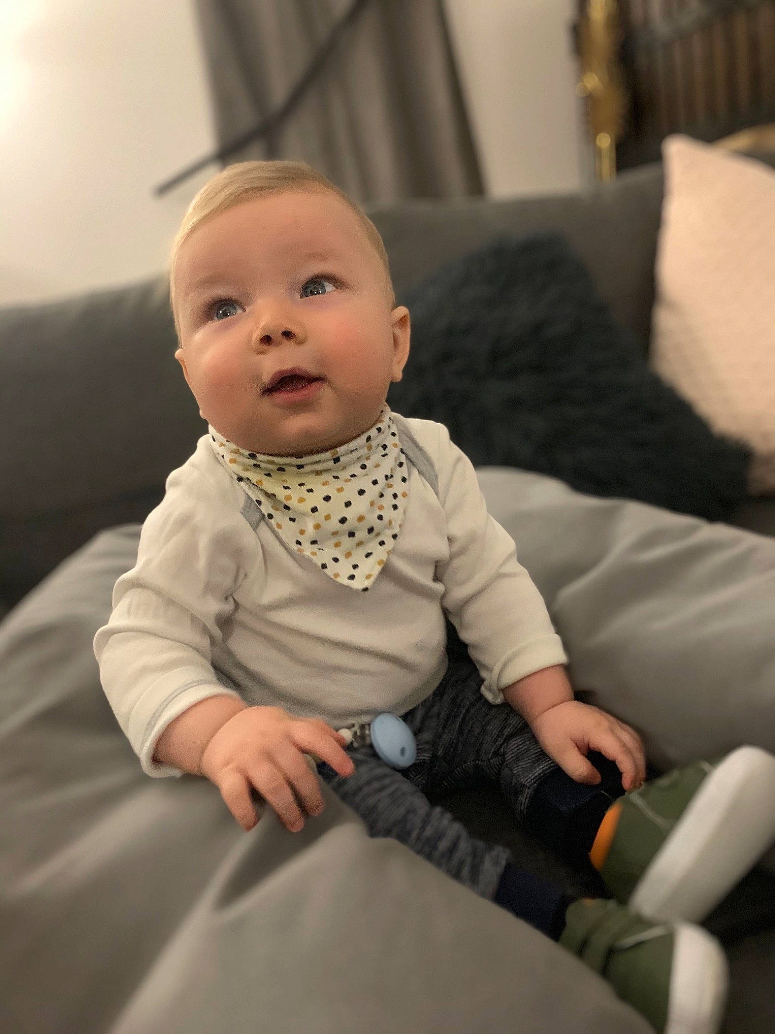 Maé participe au concours pour gagner de l'argent avec cette photo : baby, baby_toddler_clothing, cheek, child, comfort, couch, curtain, ear, eye, finger, lamp, living_room, nose, person, sitting, sock, toddler