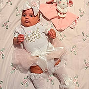 Antonella is registered to the contest to win money with this photo: baby, tutu, headband, bow, onesie, easter, toy, bunny, plush, blanket, floral_pattern, socks, cute, infant, lying_down, pink, white, child, celebration, soft_toy