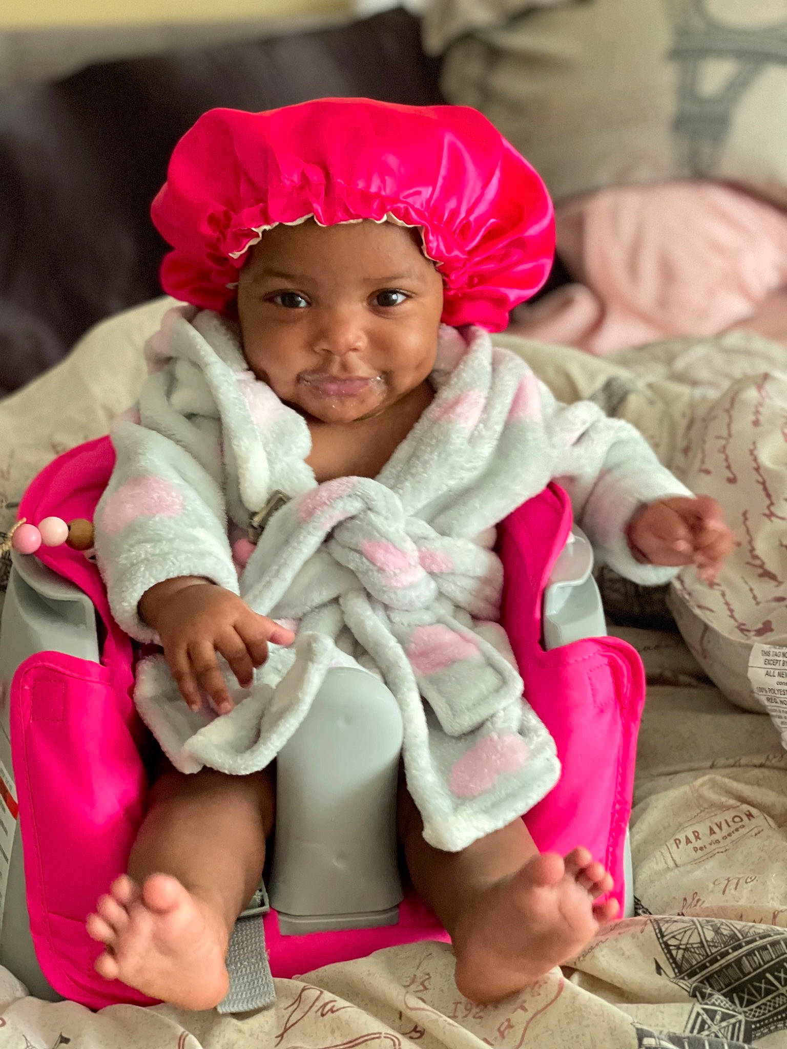 Nymira is registered to the contest to win money with this photo: baby, baby_toddler_clothing, cap, cheek, child, comfort, eye, fun, happy, headwear, linens, magenta, person, pink, sitting, skin, sleeve, smile, textile, thigh