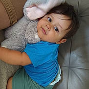 Sacha a rejoint le concours — aidez-le/la à gagner de superbes lots ! baby, blue_shirt, child, comfort, couch, cute, face, foot, green_shorts, hair, indoor, leather_couch, person, plush, relaxing, skin, soft_toy, stuffed_animal, toddler, toy