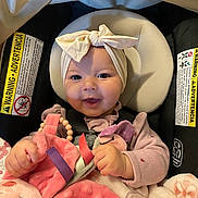 Cecilia joined the competition — help win amazing prizes! baby, child, smile, headband, car_seat, blanket, toy, pink, purple, beads, infant, clothing, safety, cute, happy, hands, face, seatbelt, plush, indoor