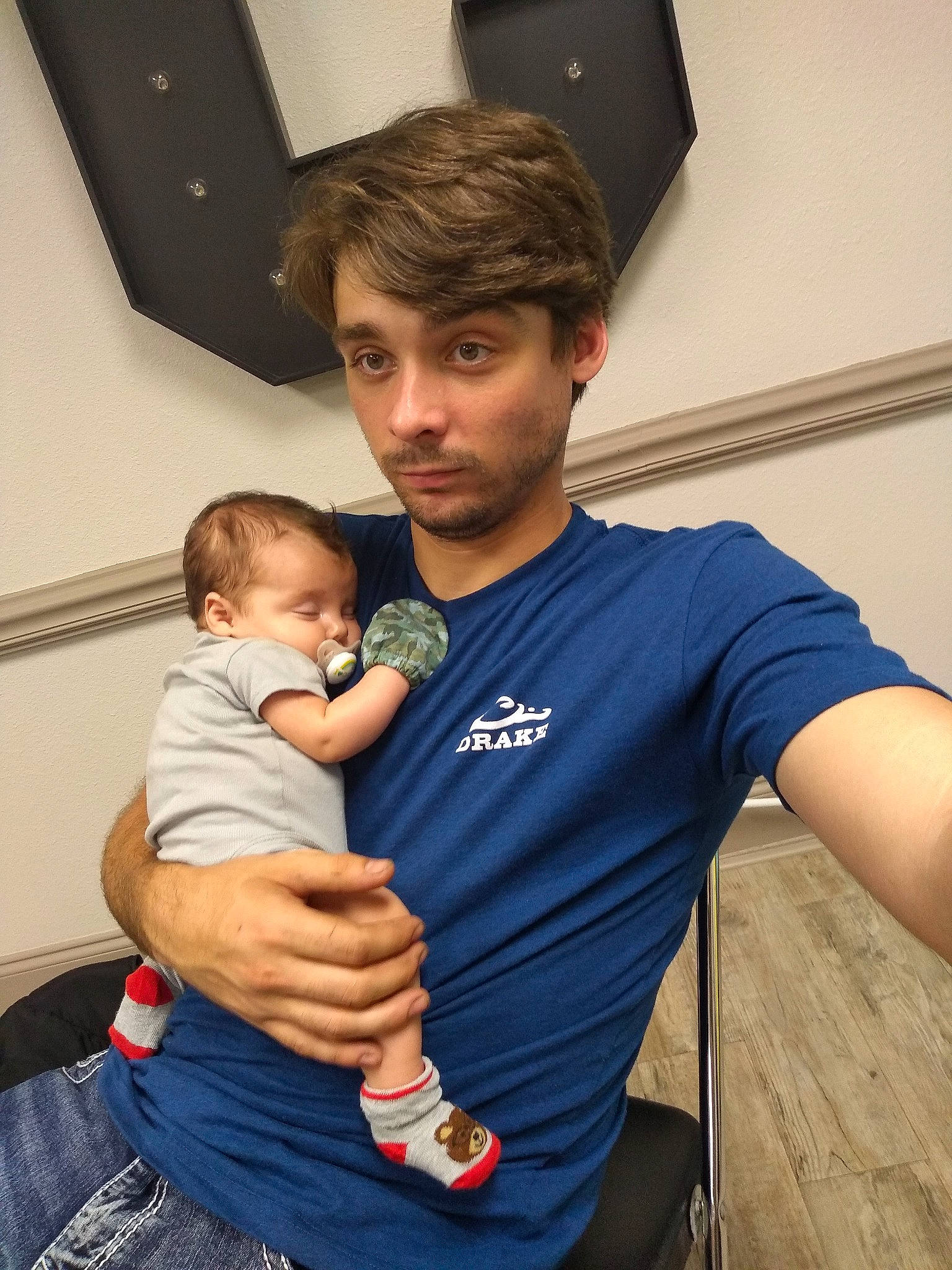 Drake is registered to the contest to win money with this photo: abdomen, arm, baby, belt, child, elbow, event, fun, gesture, hairstyle, happy, joint, leisure, muscle, person, room, shoulder, sitting, t_shirt, toddler