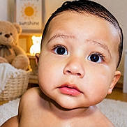 Mateo joined the competition — help win amazing prizes! baby, child, infant, portrait, face, eyes, wide_eyed, indoor, nursery, teddy_bear, stuffed_animal, cozy, warm_lighting, closeup, head, shoulders, bare_shoulders, wooden_floor, home_decor, photography