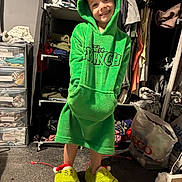 Sean joined the competition — help win amazing prizes! carpet, casual, child, closet, clothing, fabric, footwear, green_hoodie, grinch, happy, hood, indoor, person, plastic_bag, room, shelf, slippers, smile, storage, toy_slippers