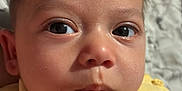 Anthony is registered to the contest to win money with this photo: baby, child, closeup, curious, cute, expression, eyes, face, head, indoors, infant, newborn, person, portrait, resting, skin, sleepwear, soft_texture, yellow_clothing, young