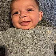 Anthony joined the competition — help win amazing prizes! apparel, baby, button, child, closeup, cozy, cute, face, gray, happy, indoor, infant, knitwear, lying_down, person, portrait, smiling, sweater, texture, warm