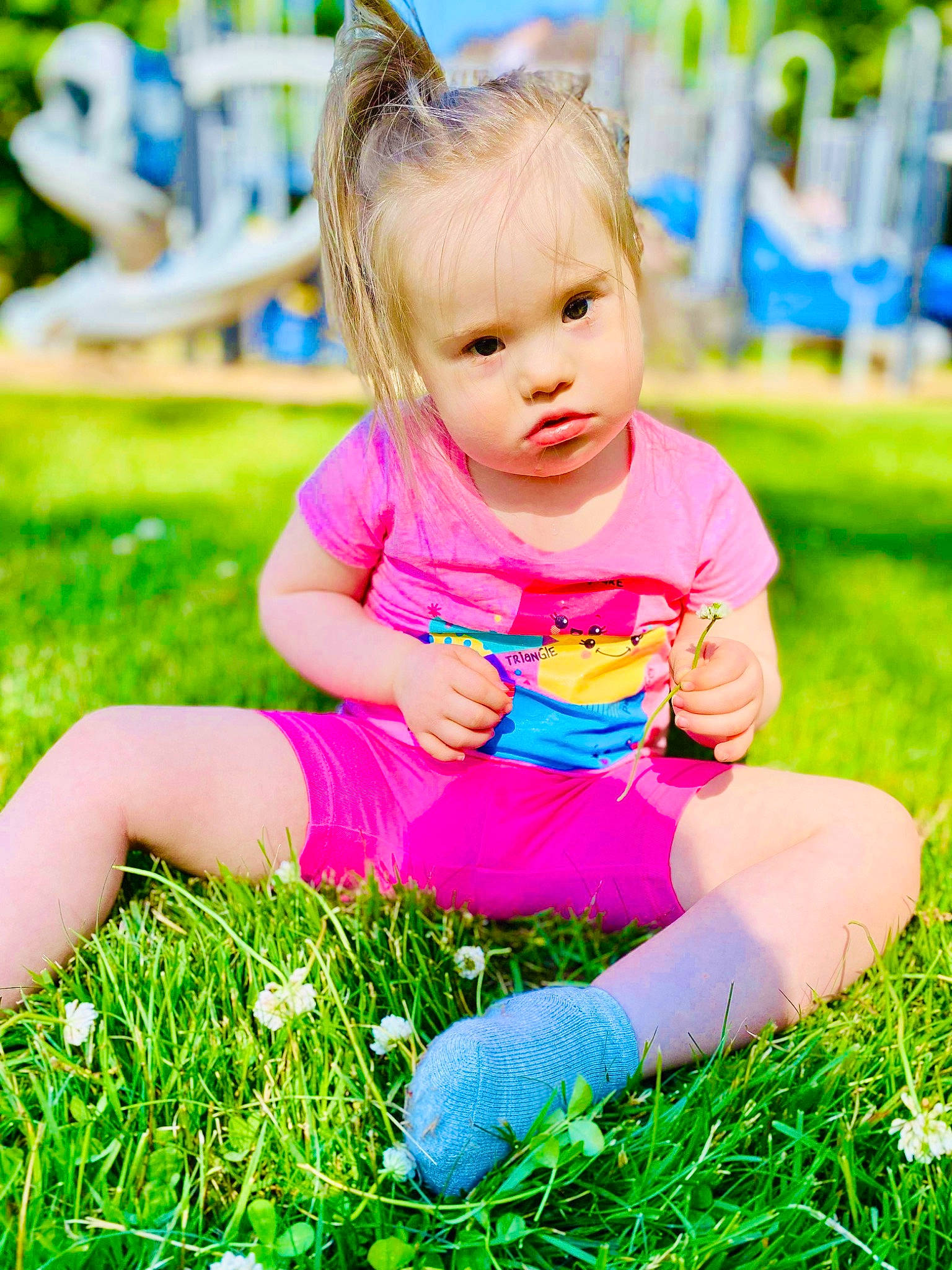 Isla is registered to the contest to win money with this photo: baby, baby_toddler_clothing, blue, child, facial_expression, grass, grass_family, green, happy, leisure, magenta, people_in_nature, person, photograph, pink, plant, shorts, skin, summer, t_shirt