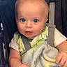 baby, infant, child, portrait, stroller, harness, blanket, sitting, wide_eyes, blue_eyes, short_hair, hands, clothing, indoor, close_up, face, cute, alert, photography, safe
