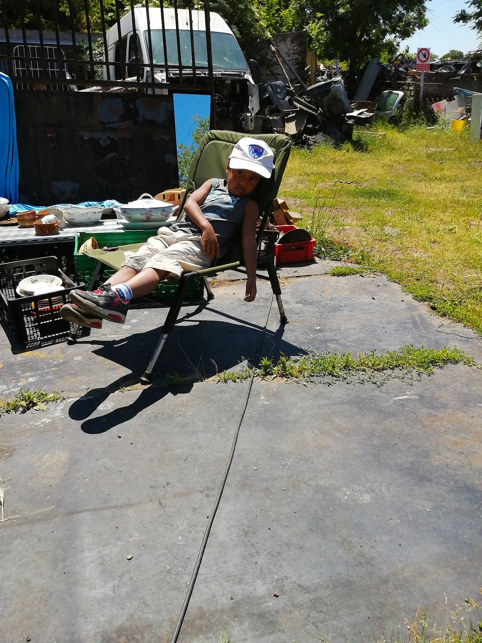 Mathias participe au concours pour gagner de l'argent avec cette photo : chair, concrete, flagstone, headwear, person, plant, sidewalk, tree