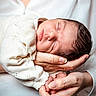 newborn, baby, sleeping, infant, hands, knitted_clothing, soft, peaceful, portrait, closeup, human, skin, white_clothing, adult, gentle, rest, cute, care, tenderness, family