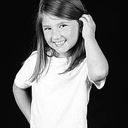 Elyna participe au concours pour gagner de l'argent avec cette photo : child, girl, smile, white_shirt, long_hair, black_background, portrait, happy, posing, young, cute, casual, standing, female, monochrome, studio, confident, hand_on_hip, playful, youth