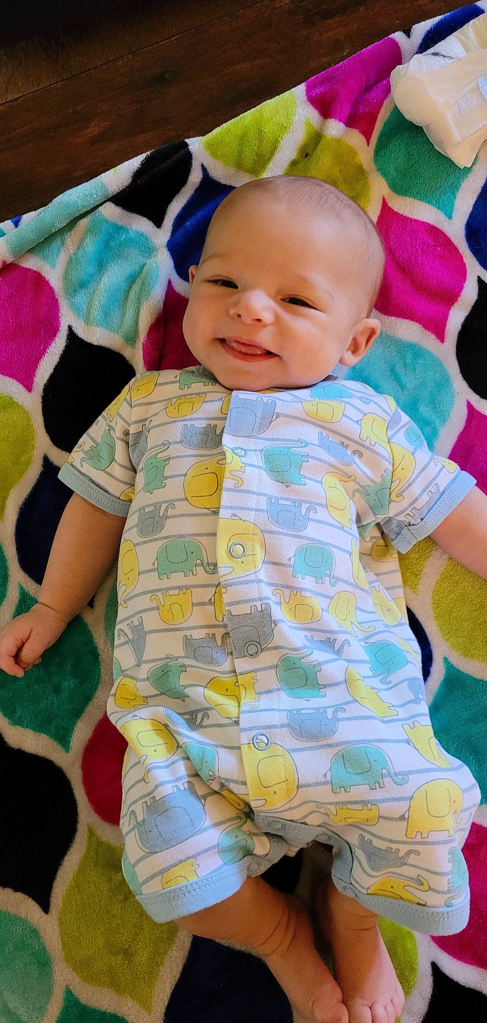 Hudson is registered to the contest to win money with this photo: arm, baby, baby_toddler_clothing, cheek, eye, face, facial_expression, happy, head, iris, organ, person, photograph, product, purple, shirt, skin, sleeve, smile, textile
