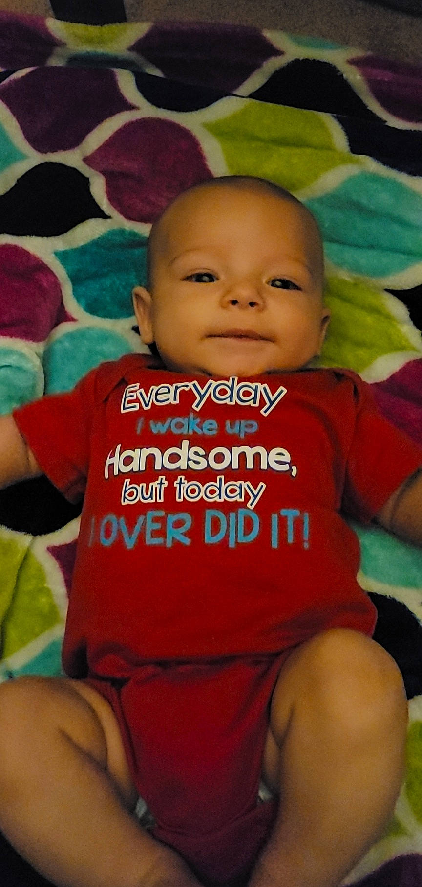 Hudson is registered to the contest to win money with this photo: baby, baby_toddler_clothing, cheek, chin, eyebrow, facial_expression, finger, green, happy, mouth, nose, orange, organ, person, pink, product, skin, sleeve, smile, t_shirt