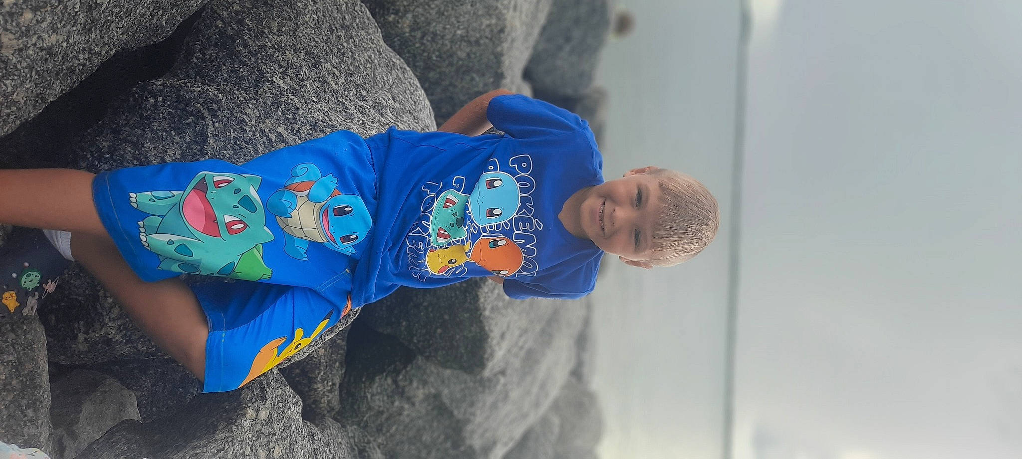 Ezekiel is registered to the contest to win money with this photo: baby_toddler_clothing, child, denim, electric_blue, font, fun, joy, leisure, linens, person, recreation, rock, sitting, sleeve, t_shirt, toddler, tree, vacation